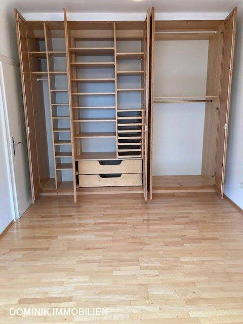Offene Einbauschränke mit Regalen und Schubladen im Schlafzimmer, bieten viel Stauraum.