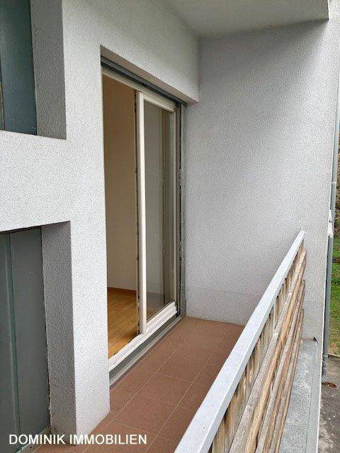 Kleiner Balkon mit Fliesenboden und Holzgeländer, zugänglich vom Schlafzimmer.