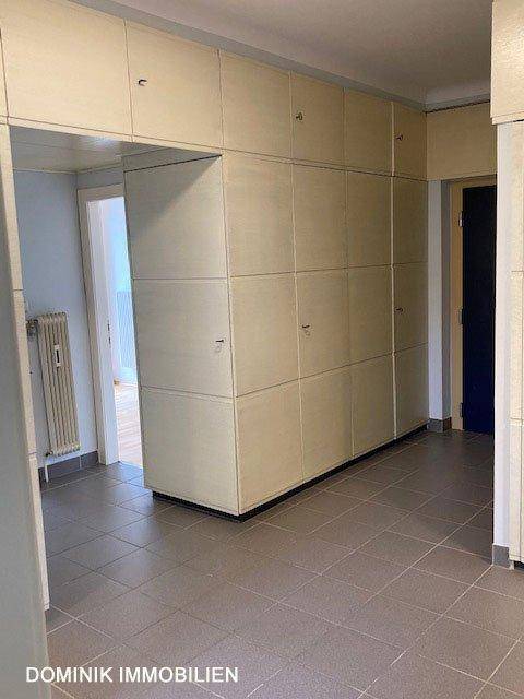 Geräumiger Flur mit umfangreichen Einbauschränken und Fliesenboden.