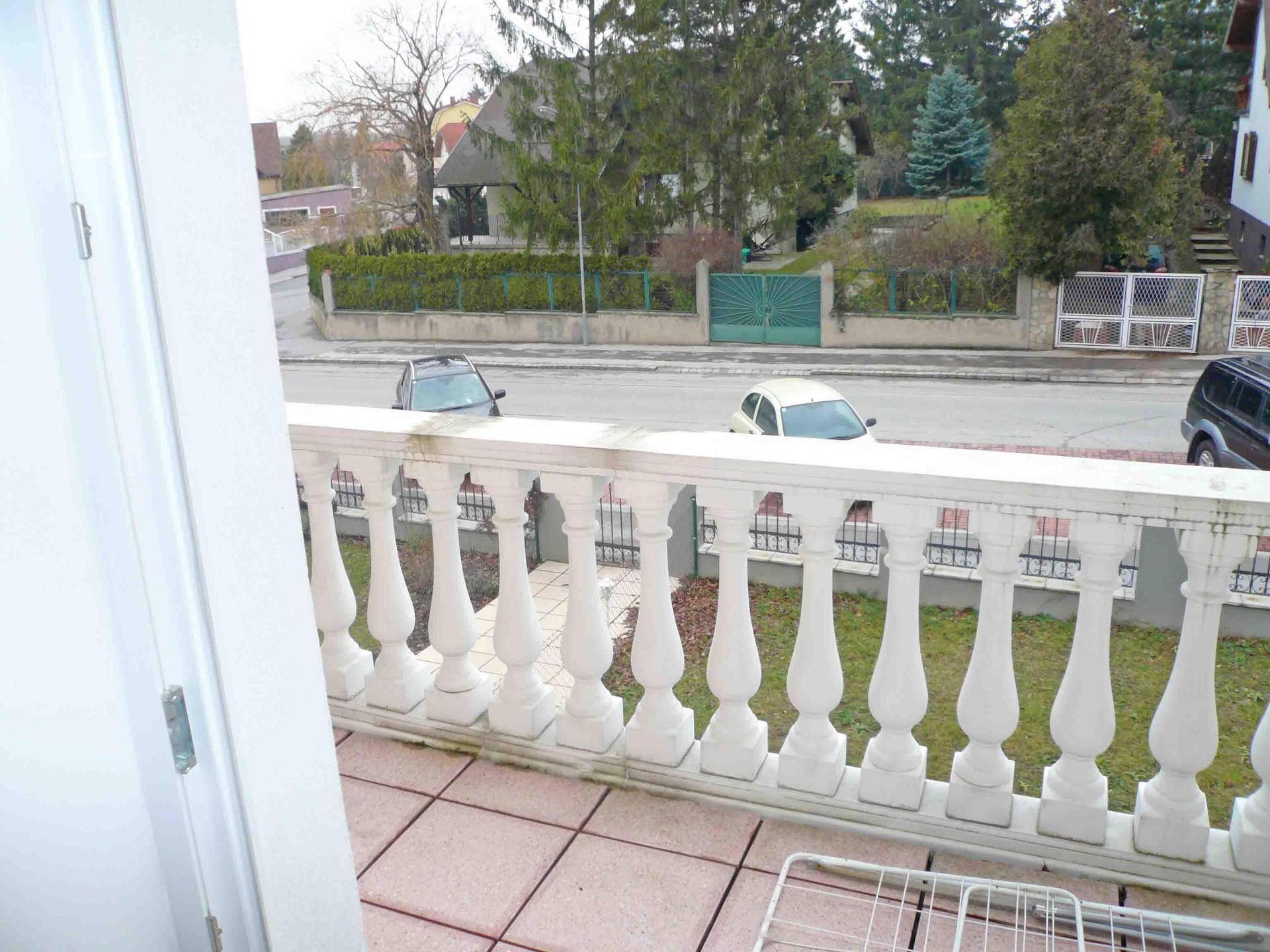 Balkon mit Balustrade und Blick auf die ruhige Wohngegend.