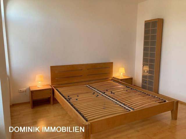 Helles Schlafzimmer mit Doppelbettrahmen aus Holz und Nachttischen.