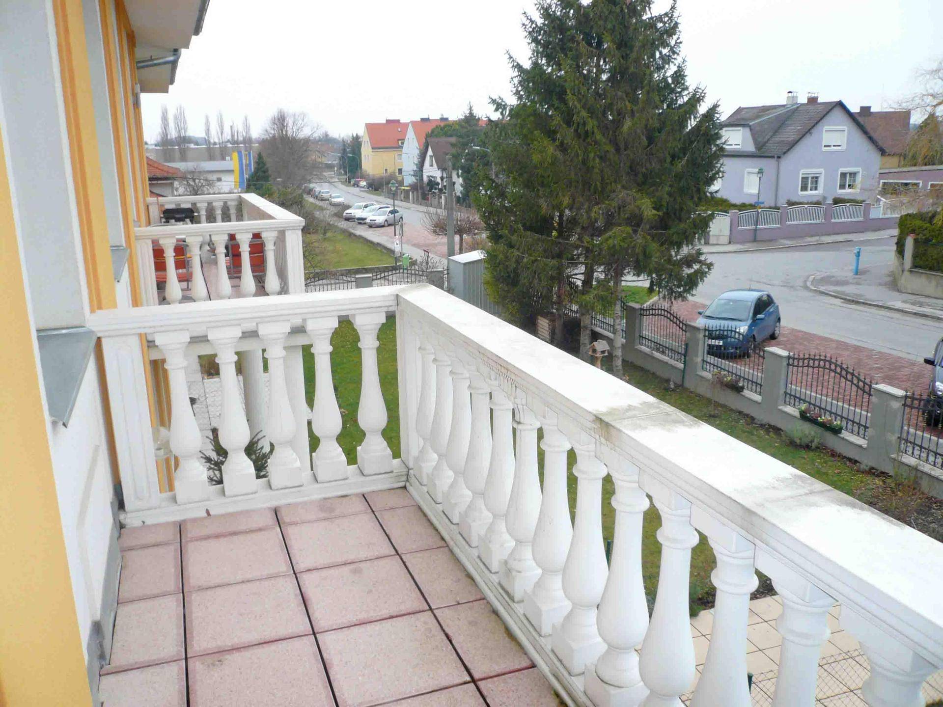 Balkon mit Balustrade und Blick auf die Straße und umliegende Häuser.