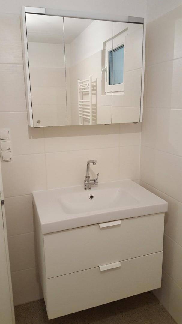 Modernes Waschbecken mit Unterschrank und Spiegelschrank im Badezimmer.