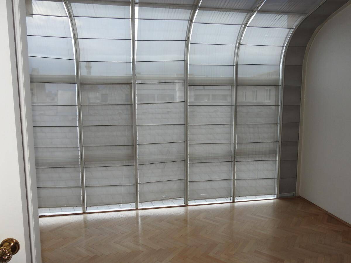 Heller Wintergarten mit beeindruckender gewölbter Glasdecke und großen Fensterflächen für viel Licht.