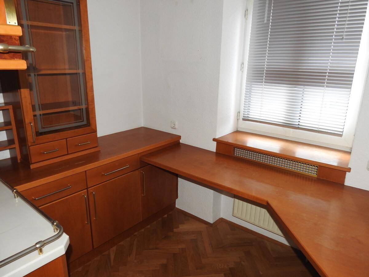 Geräumige Holzküche mit viel Stauraum und einer langen Arbeitsplatte, die sich um die Ecke erstreckt.