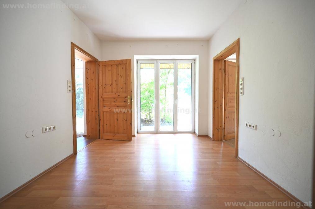 Heller Flur mit Laminatboden und mehreren Holztüren, die zu anderen Räumen führen.