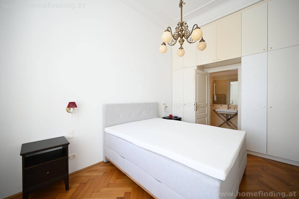 Schlafzimmer mit Bett, Einbauschränken und direktem Zugang zu einem angrenzenden Badezimmer für mehr Privatsphäre.