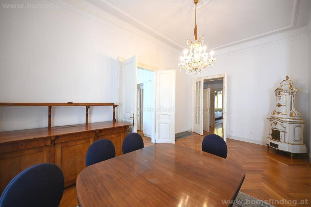 Klassischer Essbereich mit Holztisch, antikem Sideboard und einem traditionellen Kachelofen für gemütliche Abende.