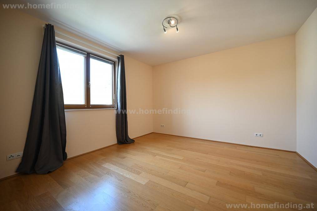 Ruhiges Schlafzimmer mit Parkettboden und einem Fenster, das für eine angenehme Belichtung sorgt, ideal zum Entspannen.