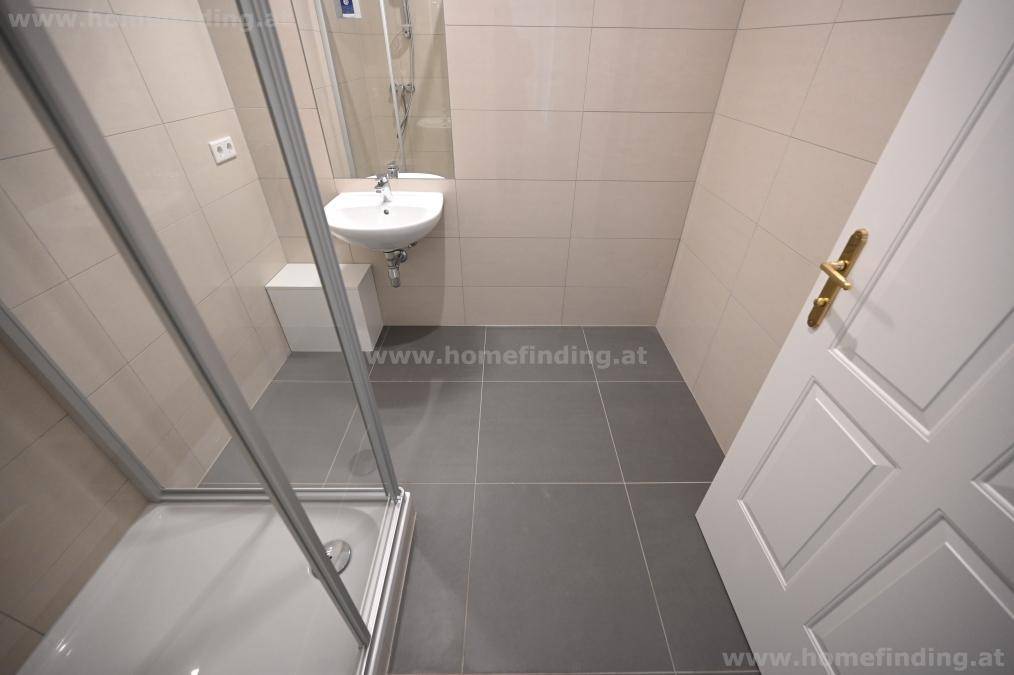 Kompaktes Badezimmer mit Duschkabine und Waschbecken, ideal als Gästebad.
