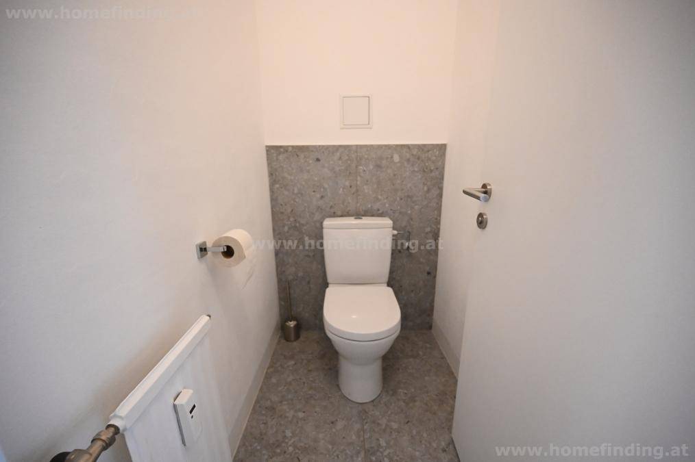 Separates WC mit moderner Toilette und Fliesen an der Wand, praktisch und funktional gestaltet.