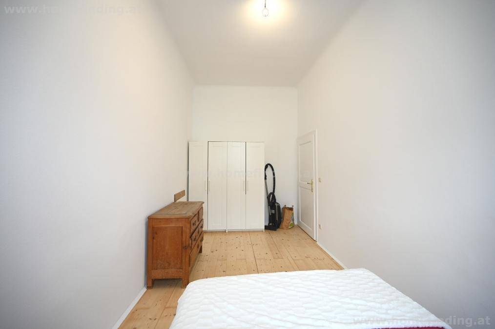 Schlafzimmer mit Holzboden, einem Kleiderschrank und einer Kommode, bietet ausreichend Stauraum.
