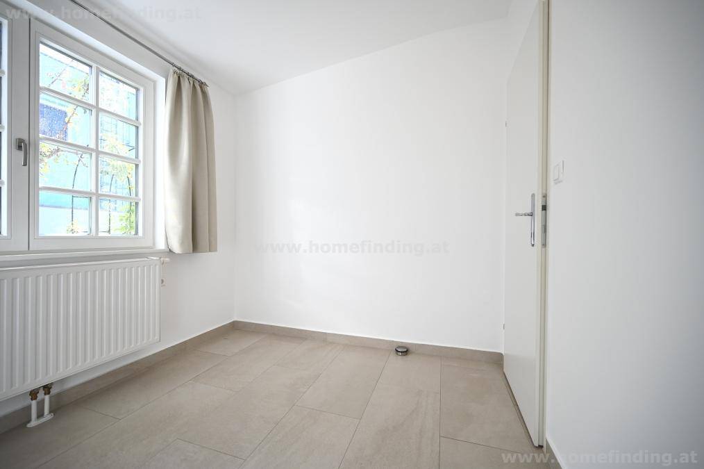 Geräumiges Schlafzimmer mit Fenster, Heizkörper und weiß gestrichenen Wänden.