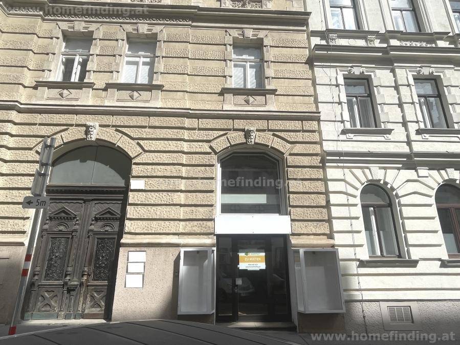 Historische Fassade eines Altbaus mit aufwendigen Verzierungen und großen Fenstern in der Stadt.