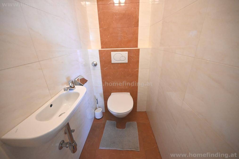 Separates WC mit Bidet, wandhängender Toilette und modernen Fliesen.