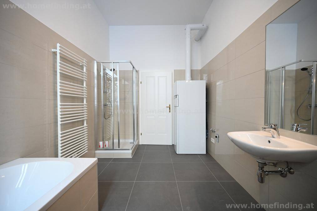 Helles Badezimmer mit Duschkabine, Einzelwaschbecken und praktischem Handtuchheizkörper.