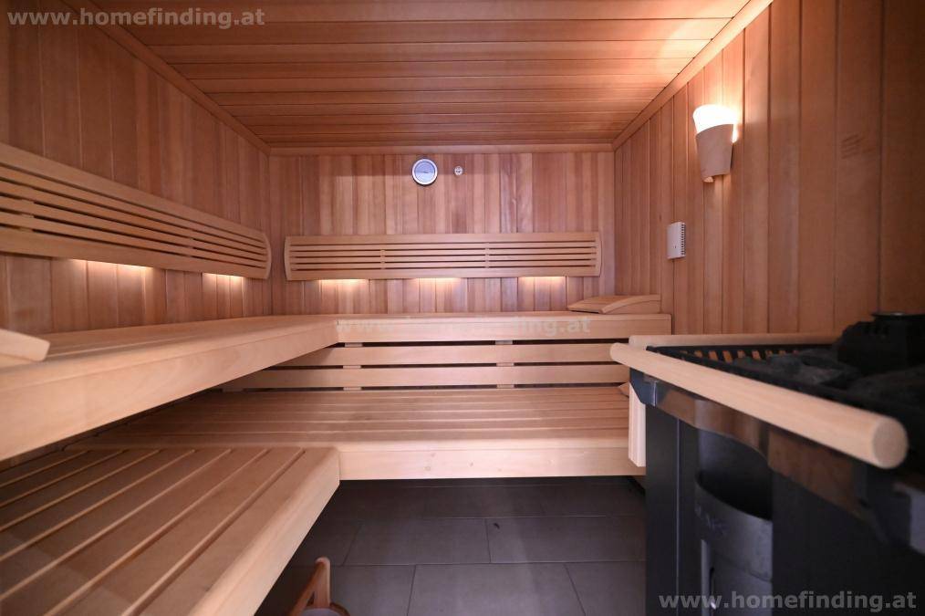 Gemütliche Holzsauna mit mehreren Bänken und einem Saunaofen, ideal zur Entspannung und Erholung.