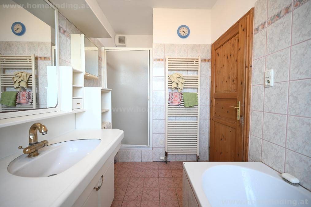 Badezimmer mit Dusche, Badewanne, Waschbecken und beheiztem Handtuchhalter.