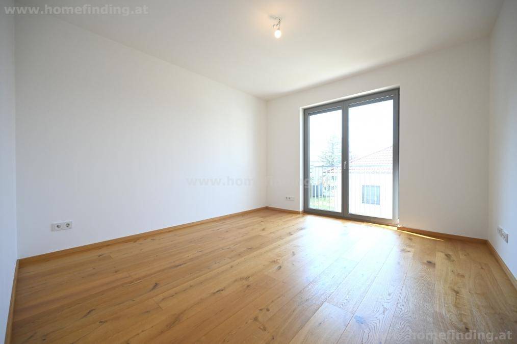 Geräumiges Zimmer mit Eichenparkett und viel Tageslicht durch die große Balkontür.