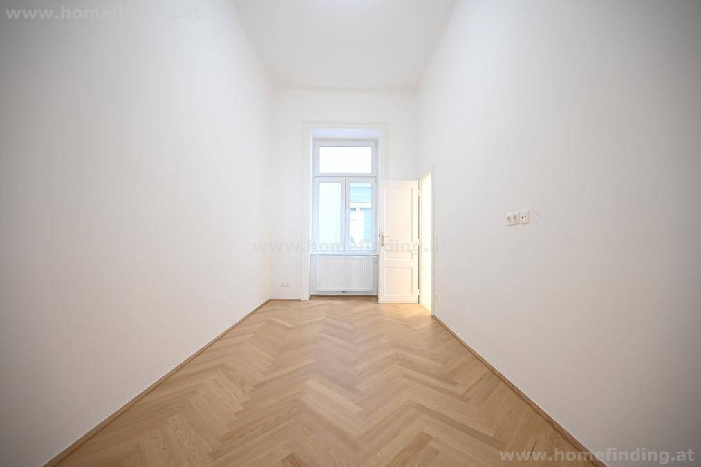 Schmaler, heller Raum mit Fischgrätparkett und einem Fenster, ideal als Schlaf- oder Arbeitszimmer.