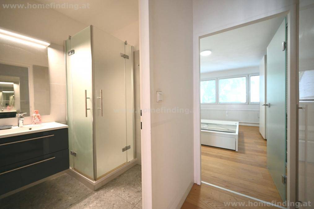 Modernes Badezimmer mit Waschtisch, Spiegelschrank und Duschkabine aus Glas, direkt vom Flur zugänglich.