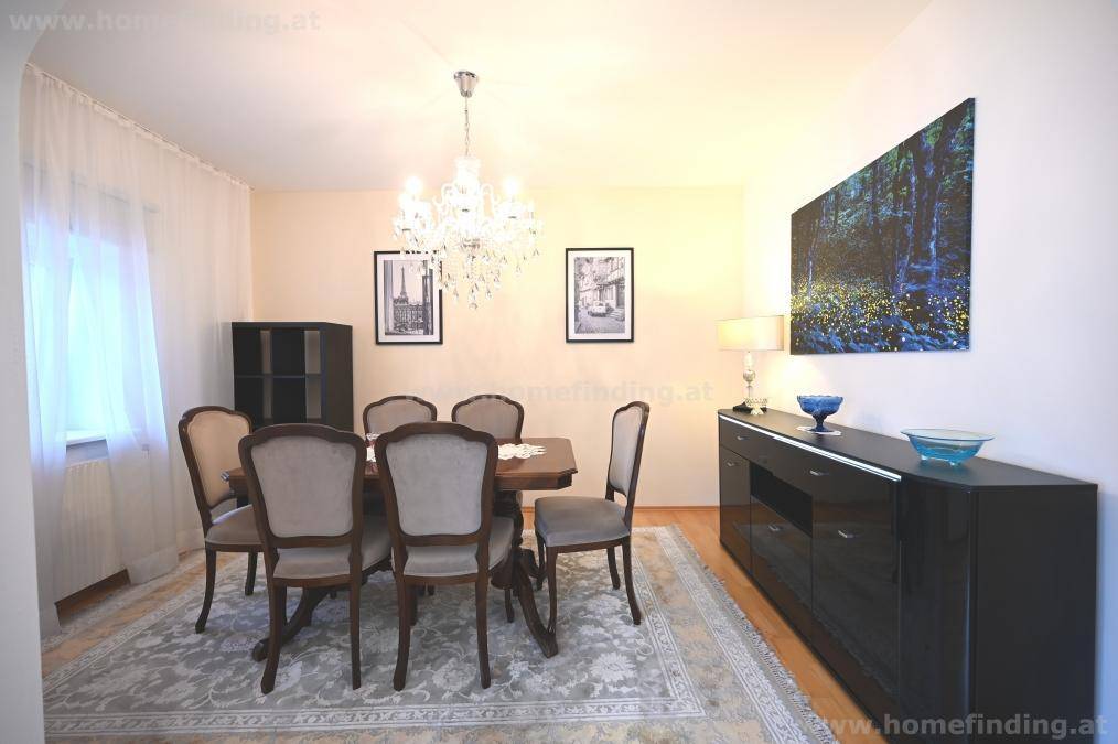 Stilvoller Essbereich mit dunklem Sideboard, Kunstwerk und klassischem Esstisch für gesellige Runden.