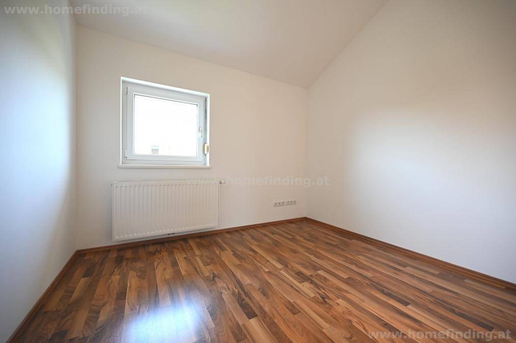 Kleineres Schlafzimmer oder Gästezimmer mit Parkettboden und einem Fenster für Tageslicht.
