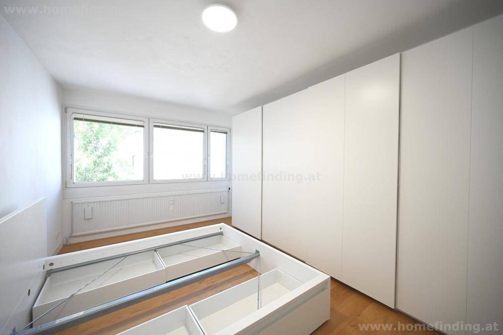 Schlafzimmer mit Einbauschränken, Holzboden und viel Tageslicht durch die Fenster, bietet viel Stauraum.