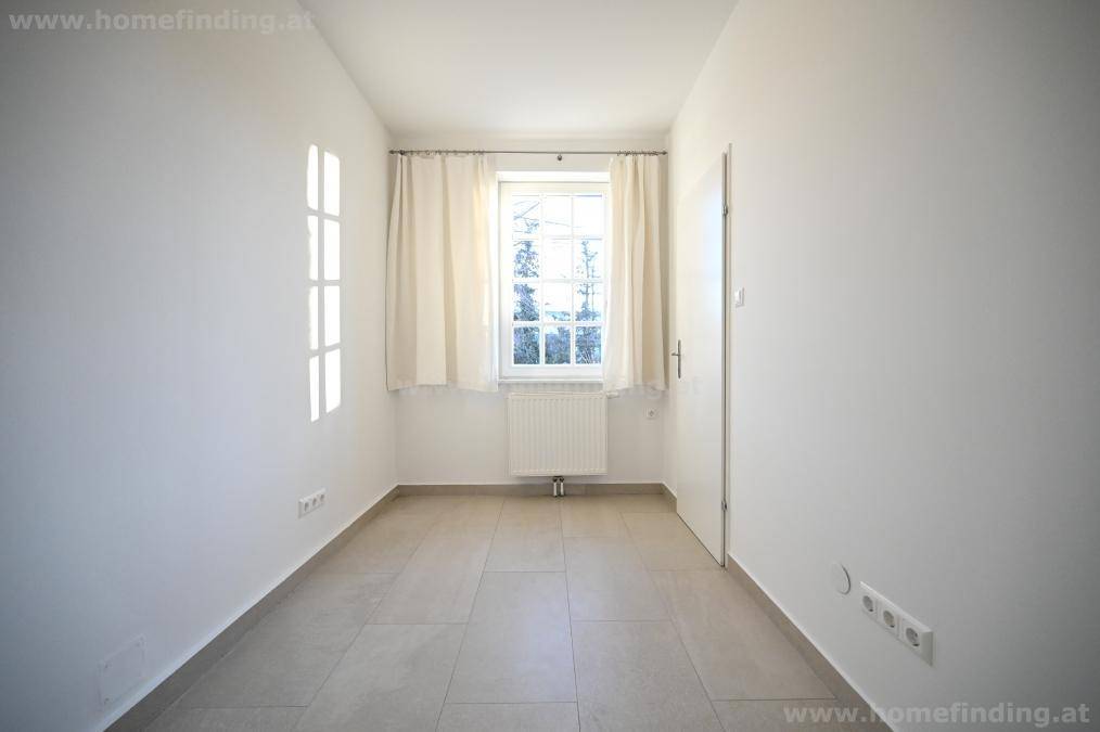 Schmaler, heller Raum mit Fliesenboden und Fenster, vielseitig nutzbar als Durchgang oder kleines Zimmer.