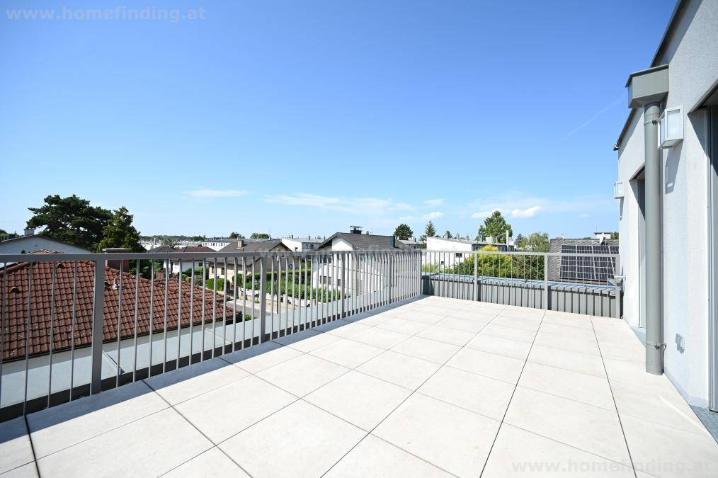 Geräumige Dachterrasse mit Fliesenboden und weitem Blick über die umliegende Wohngegend.