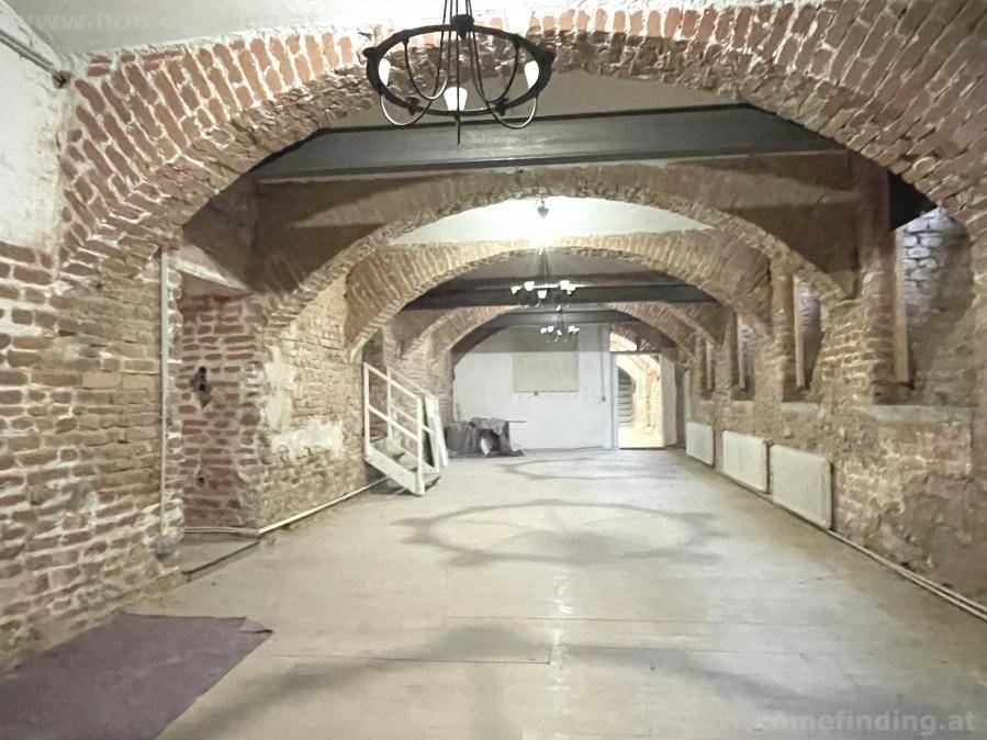 Historischer Kellerraum mit beeindruckenden Ziegelgewölben und freiliegenden Backsteinwänden, rustikaler Charme.