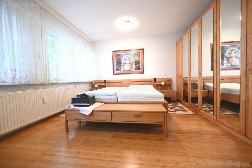 Schlafzimmer mit Doppelbett, Nachttischen und großem Spiegelschrank auf Holzboden.