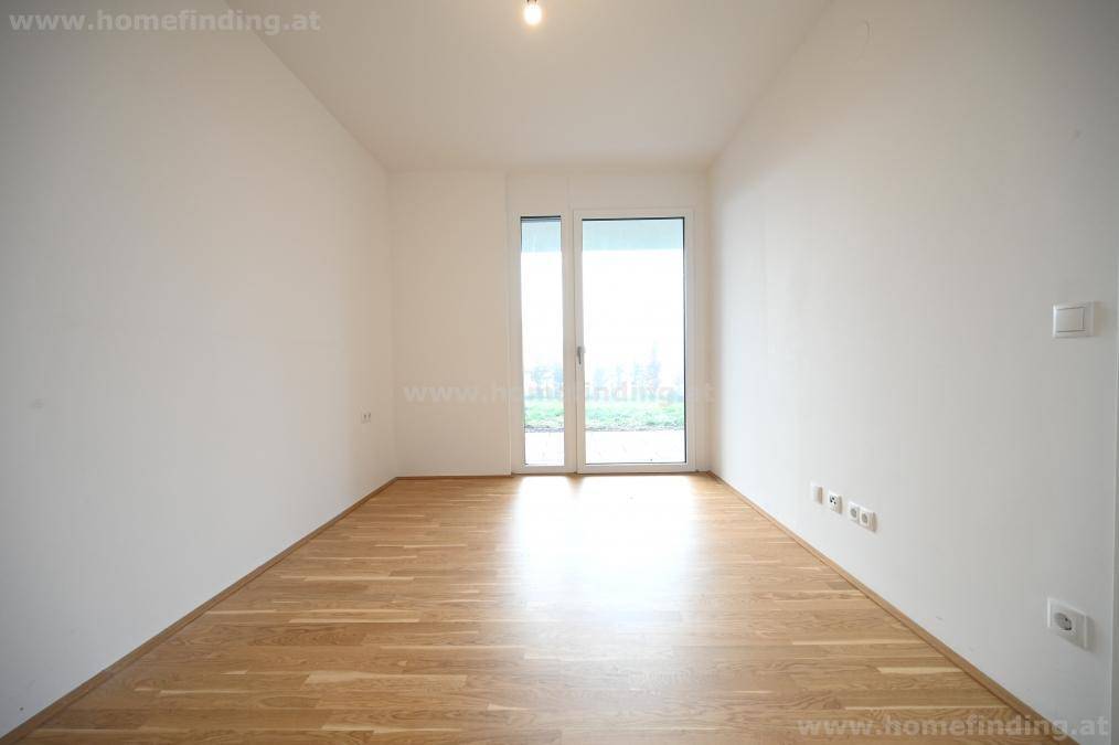Lichtdurchflutetes Schlafzimmer mit hellem Parkettboden und direktem Zugang zum Außenbereich, ideal für Ruhe und Erholung.