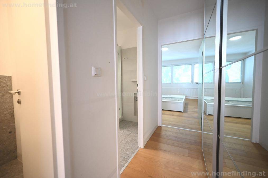 Heller Flur mit Spiegelschränken, der zu Bad und Schlafzimmer führt und viel Stauraum bietet.