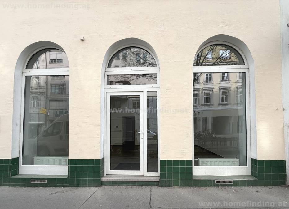 Gebäudefassade mit drei großen Rundbogenfenstern und einer Eingangstür, im Erdgeschoss gelegen.
