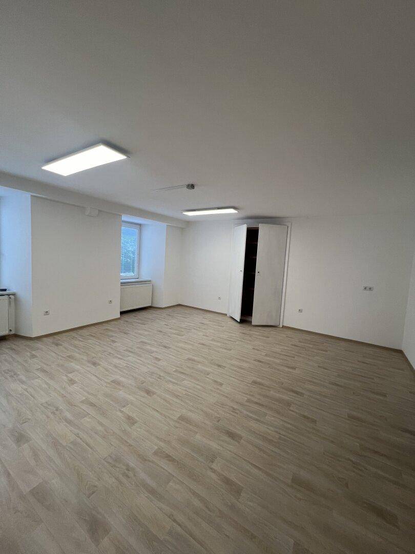 Heller, leerer Raum mit Laminatboden, weißen Wänden und einem Schrank, ideal für verschiedene Nutzungen.