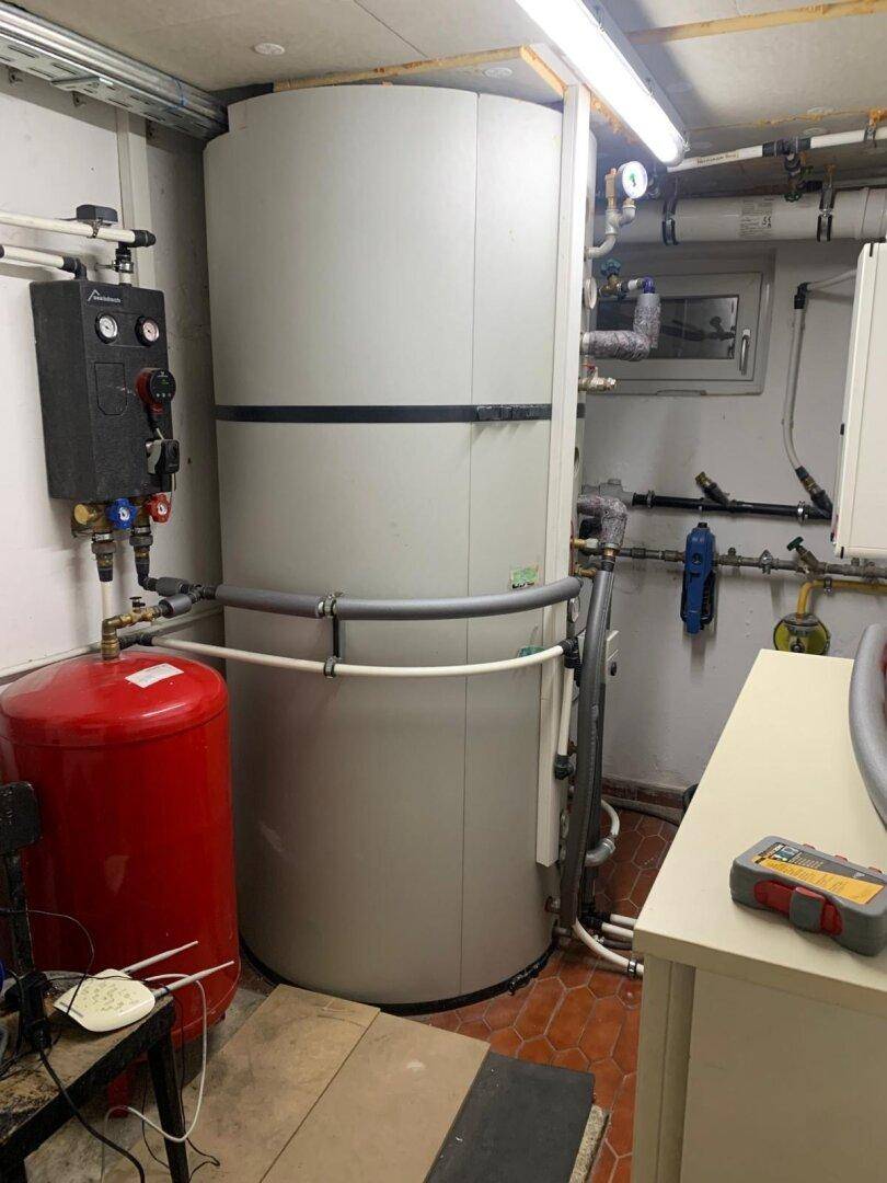 Technikraum im Keller mit moderner Heizungsanlage und Warmwasserspeicher für das Gebäude.