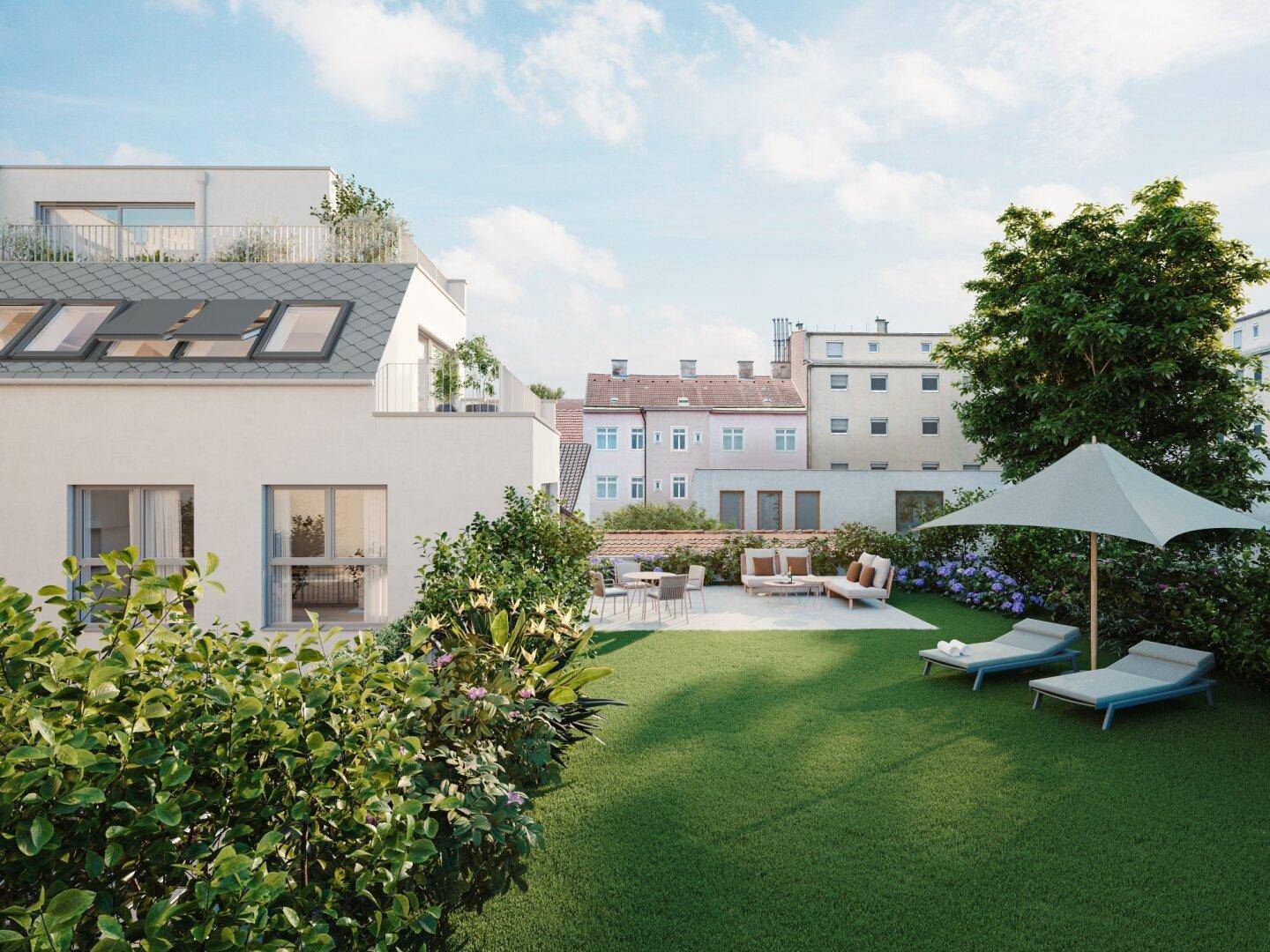 Gepflegter Garten mit Rasenfläche, Sonnenterrasse und Liegestühlen, umgeben von grünen Büschen.