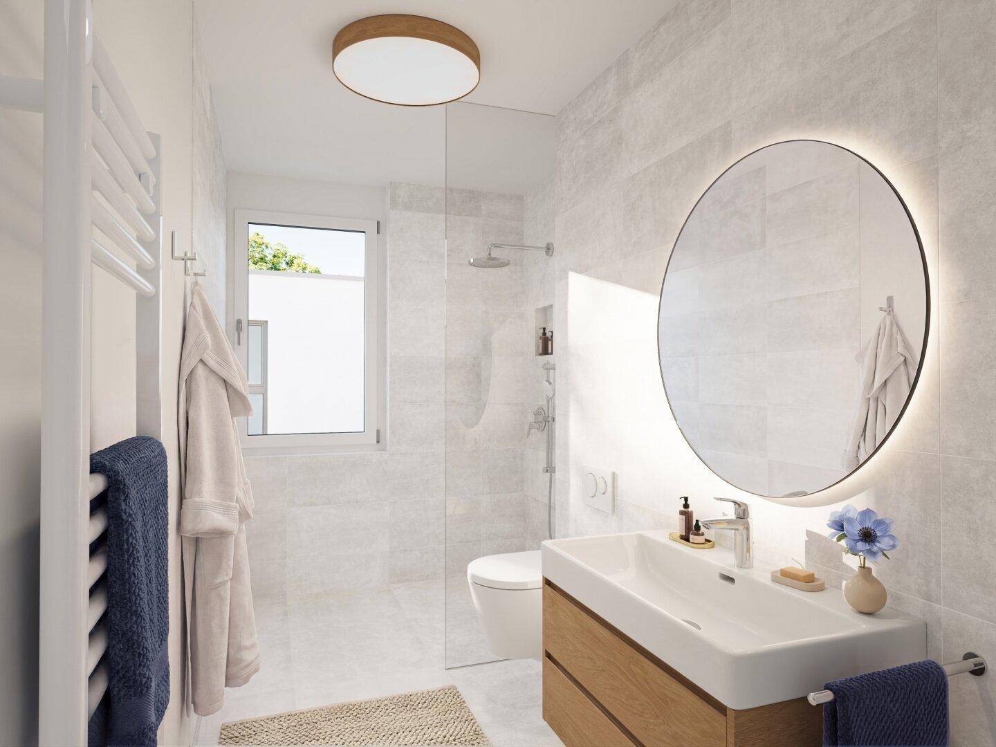 Modernes Badezimmer mit großen hellgrauen Fliesen, begehbarer Dusche und beleuchtetem Spiegel.