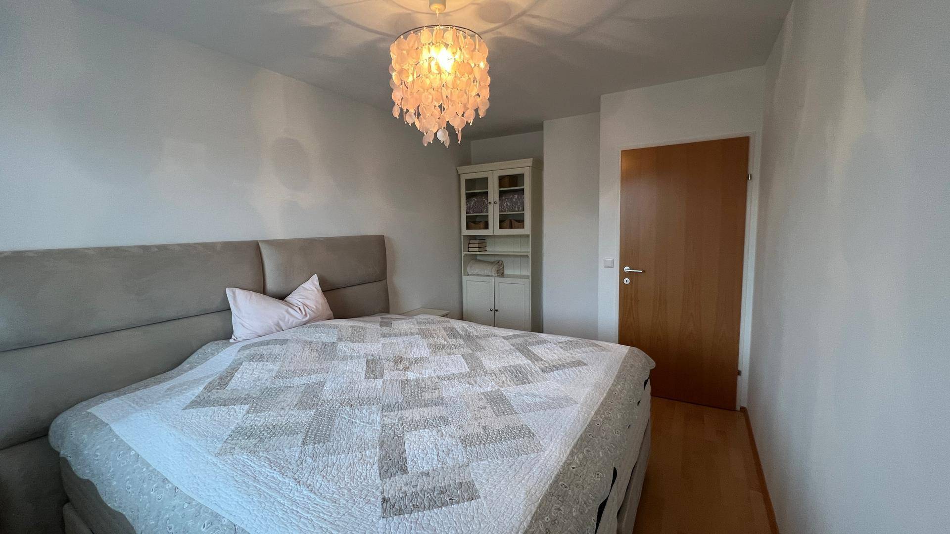 Helles Schlafzimmer mit großem Bett und Schrank, ideal für Ruhe und Erholung.