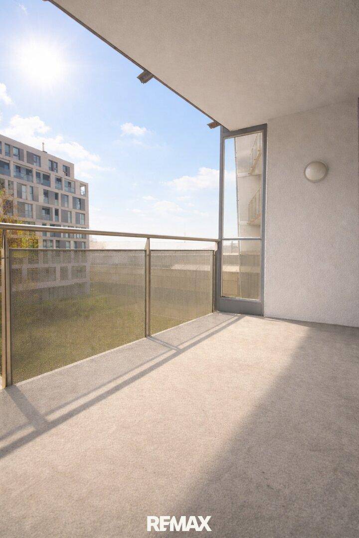 Heller Balkon mit Metallgeländer und Blick auf umliegende Gebäude.