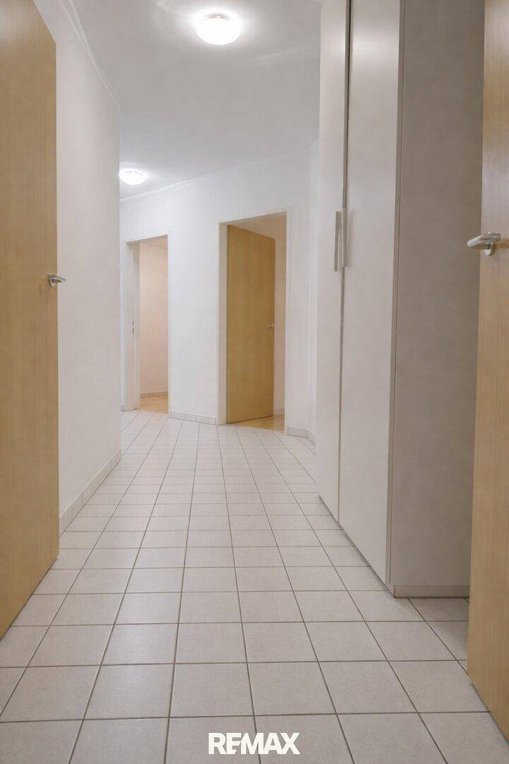 Geräumiger Flur mit Fliesenboden, Einbauschränken und Zugang zu weiteren Räumen.