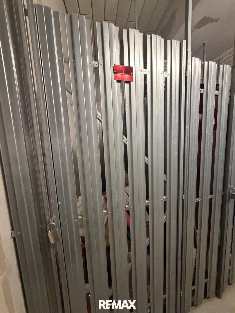 Abstellraum im Keller mit abschließbaren Metallabtrennungen für persönlichen Stauraum.