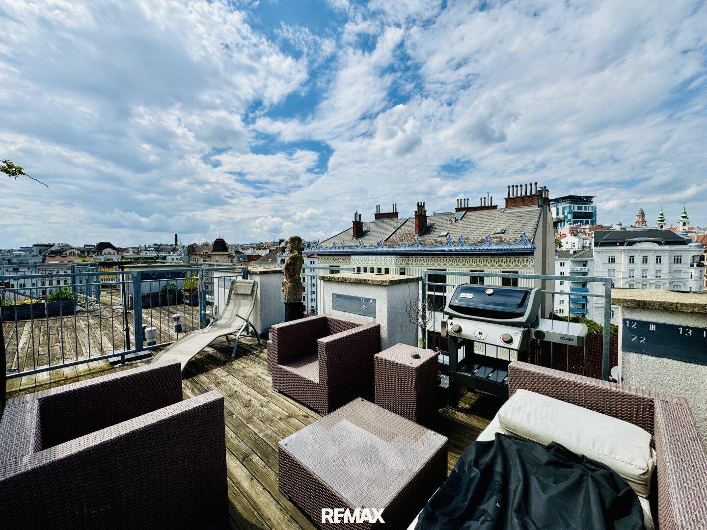 Dachterrasse mit Lounge-Möbeln, Grillbereich und weitem Blick über die Stadt.