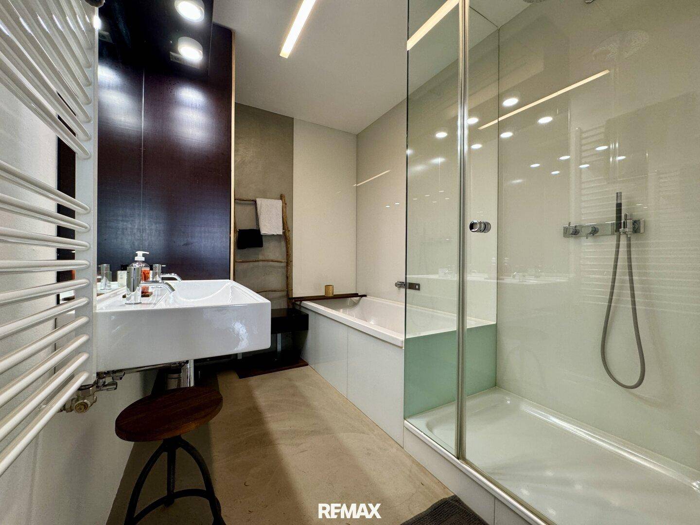 Modernes Badezimmer mit Doppelwaschbecken, Badewanne und separater Glasdusche.