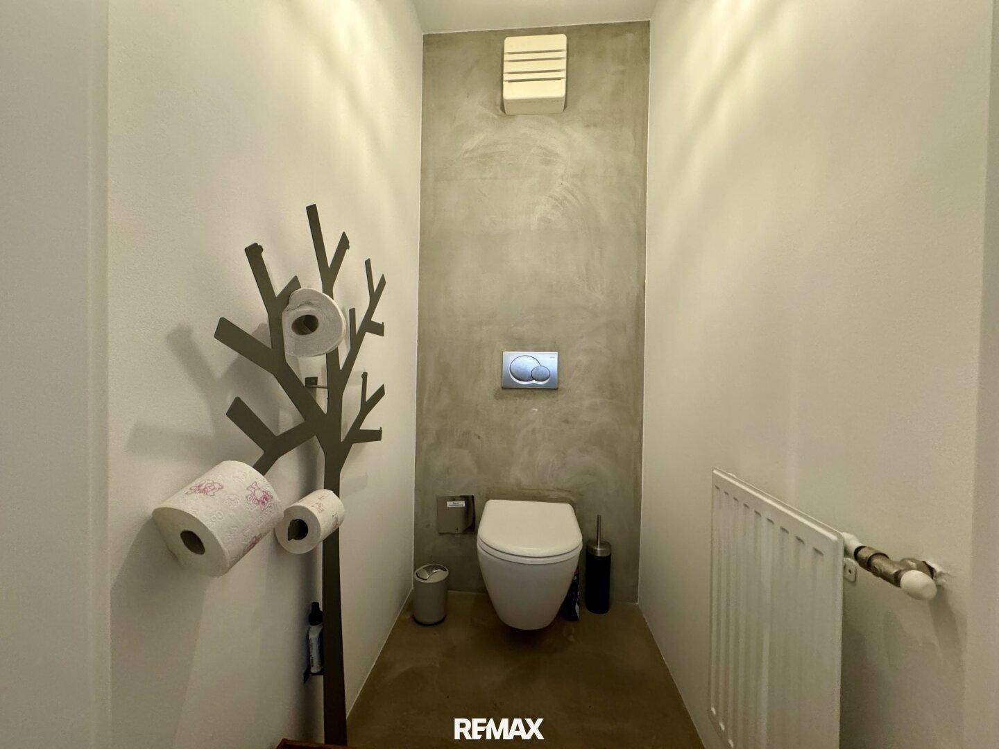 Modernes Gäste-WC mit wandhängender Toilette und minimalistischem Design.