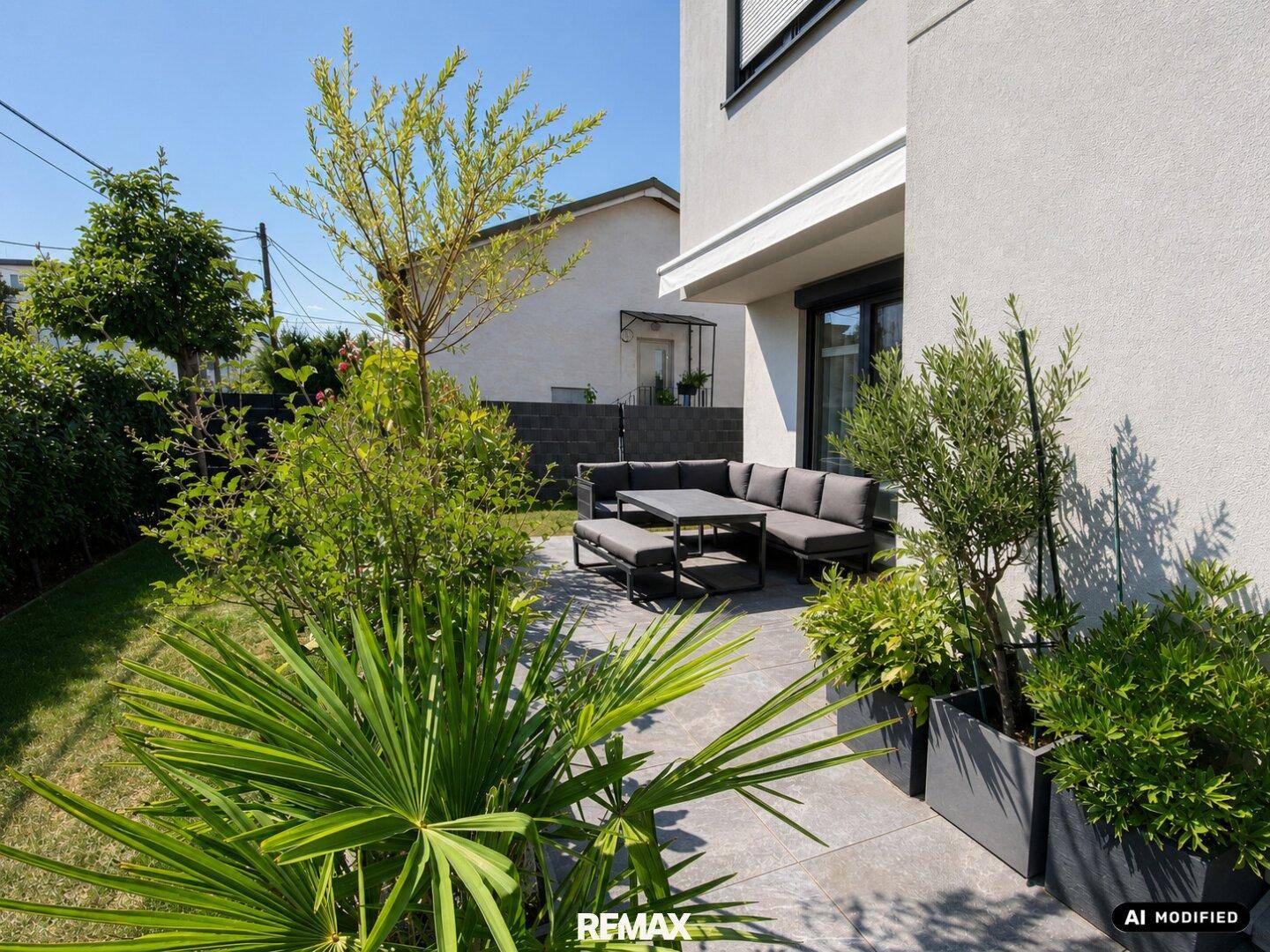 Gepflegter Garten mit Terrasse, Pflanzen und Sitzbereich.