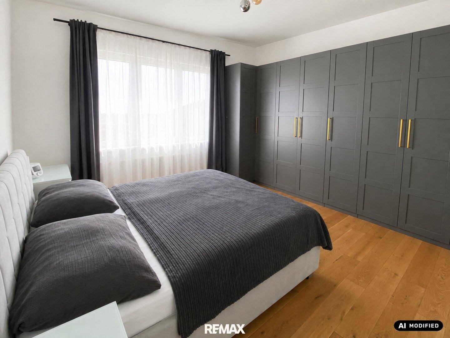 Schlafzimmer mit Holzboden, großem Kleiderschrank und bequemen Doppelbett.