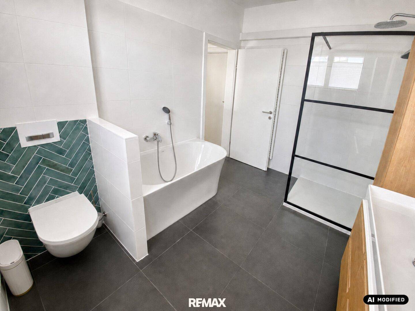 Modernes Badezimmer mit Badewanne, Dusche und grünen Akzentfliesen.