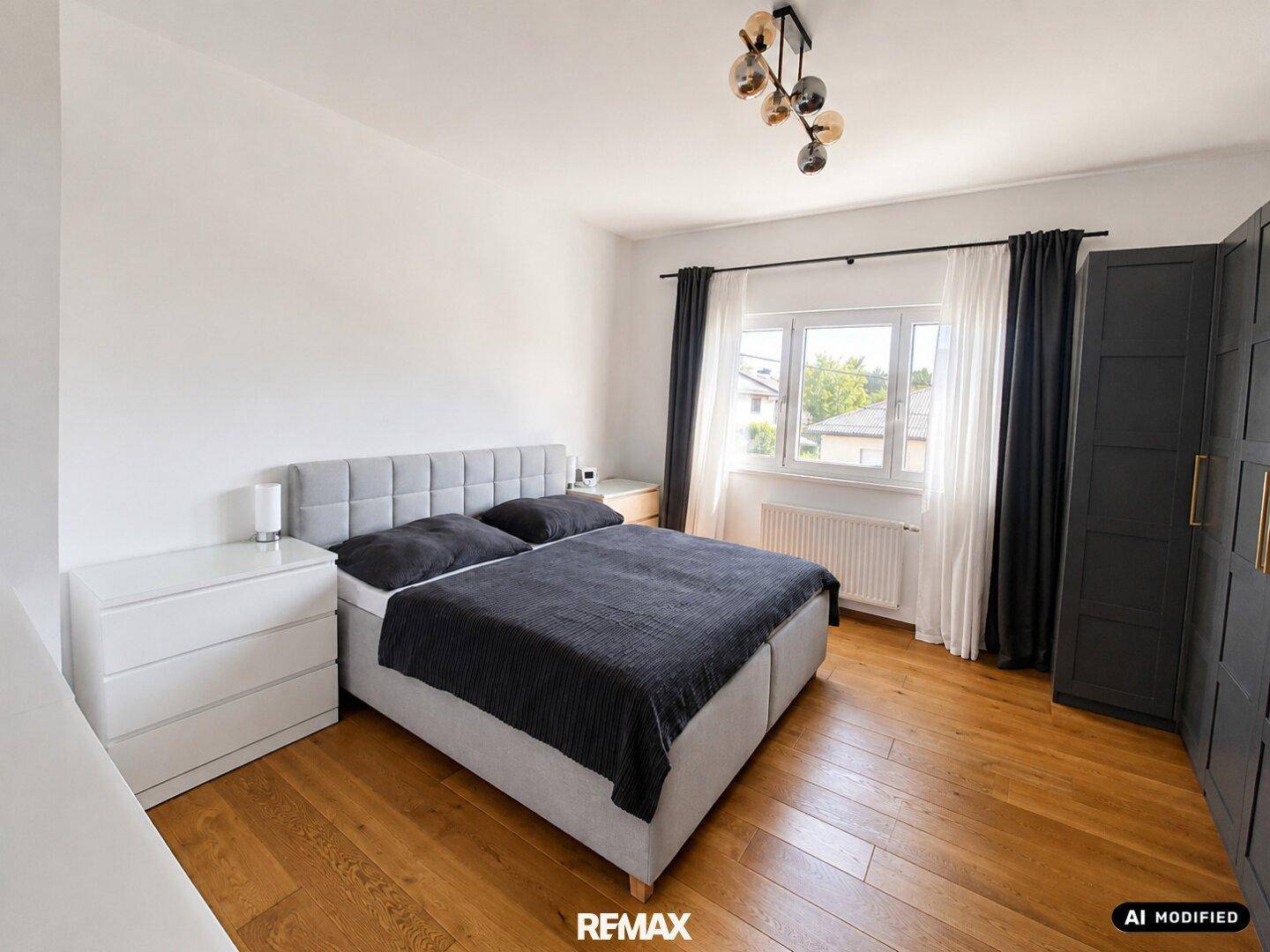 Gemütliches Schlafzimmer mit Holzboden, Doppelbett und dunklem Kleiderschrank.